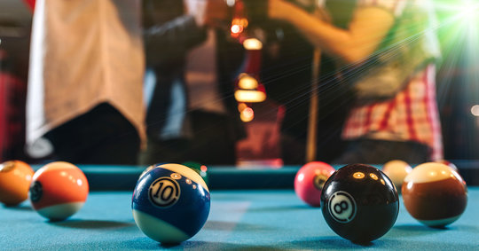 billiards table with people behind it