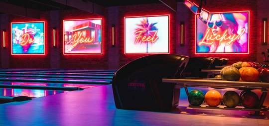 Bowling lanes with neon signs in the background